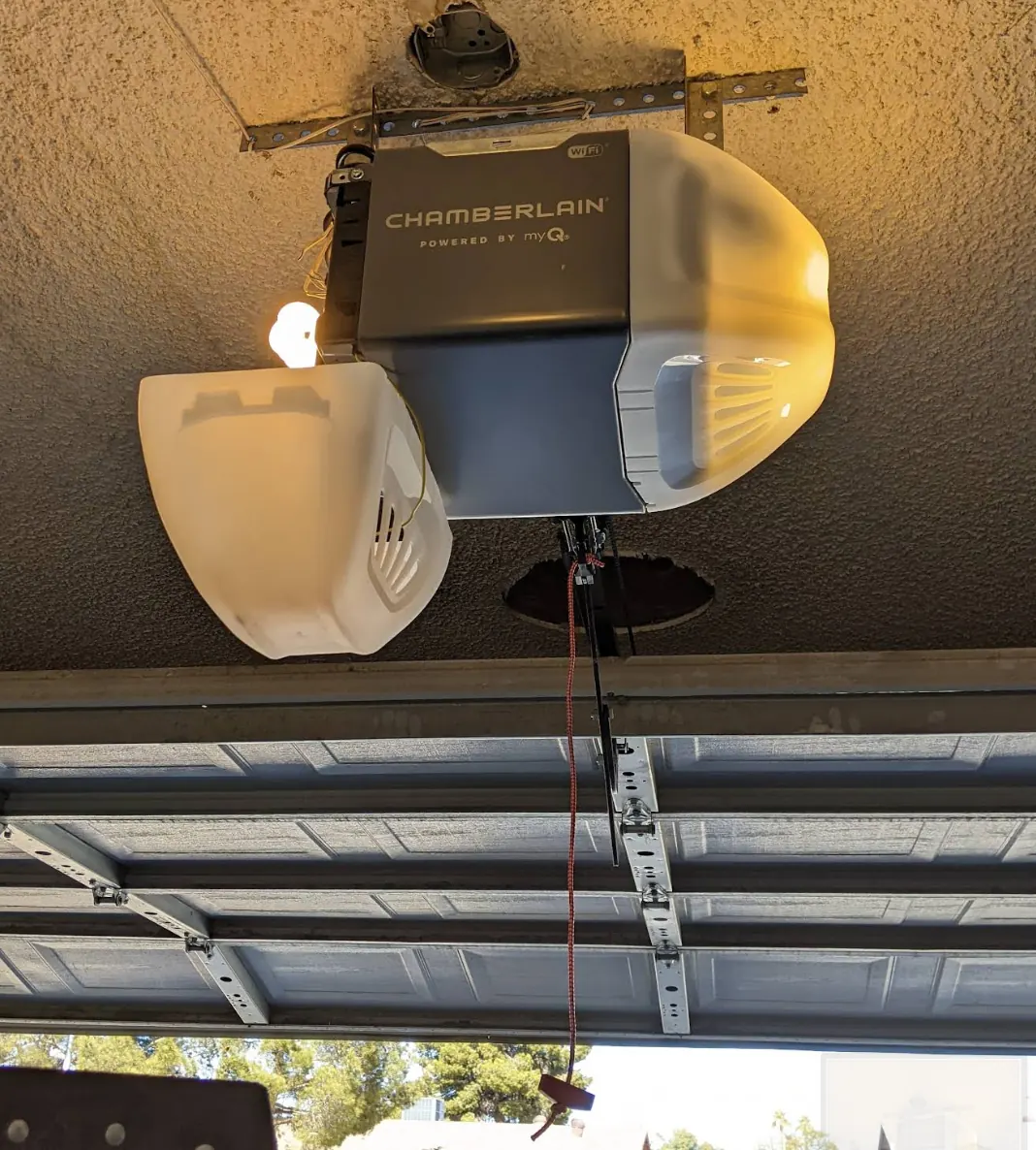 Chamberlain garage door opener mounted above a sectional garage door